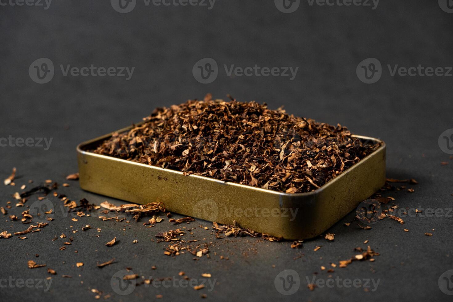 fine tobacco in a gold iron box on a black table photo