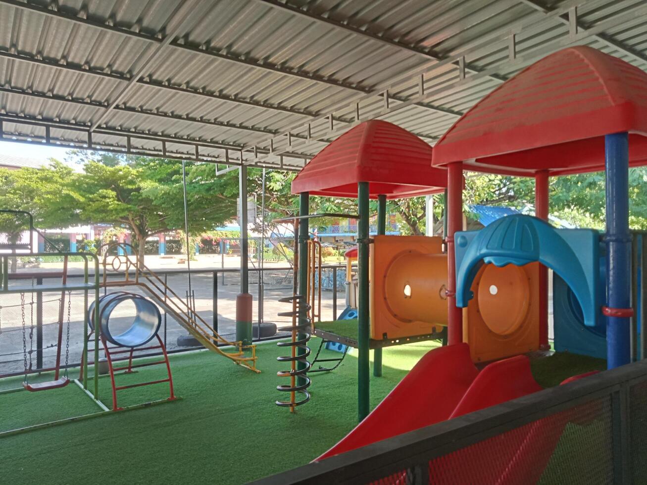 a play area with a slide, swings and other toys photo