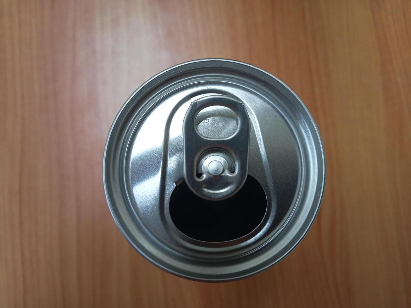 a can of soda on a wooden table photo