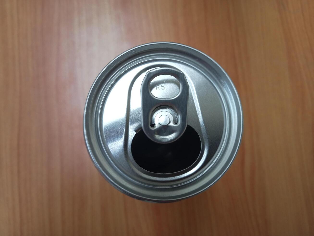 a can of soda on a wooden table photo