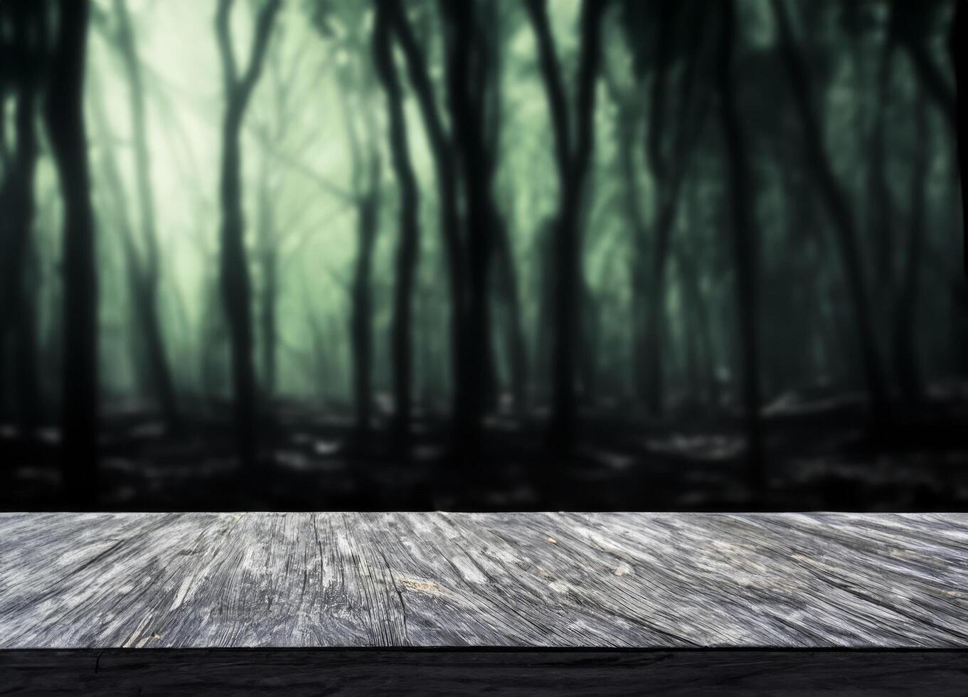 Black wood table with blurred horror forest photo
