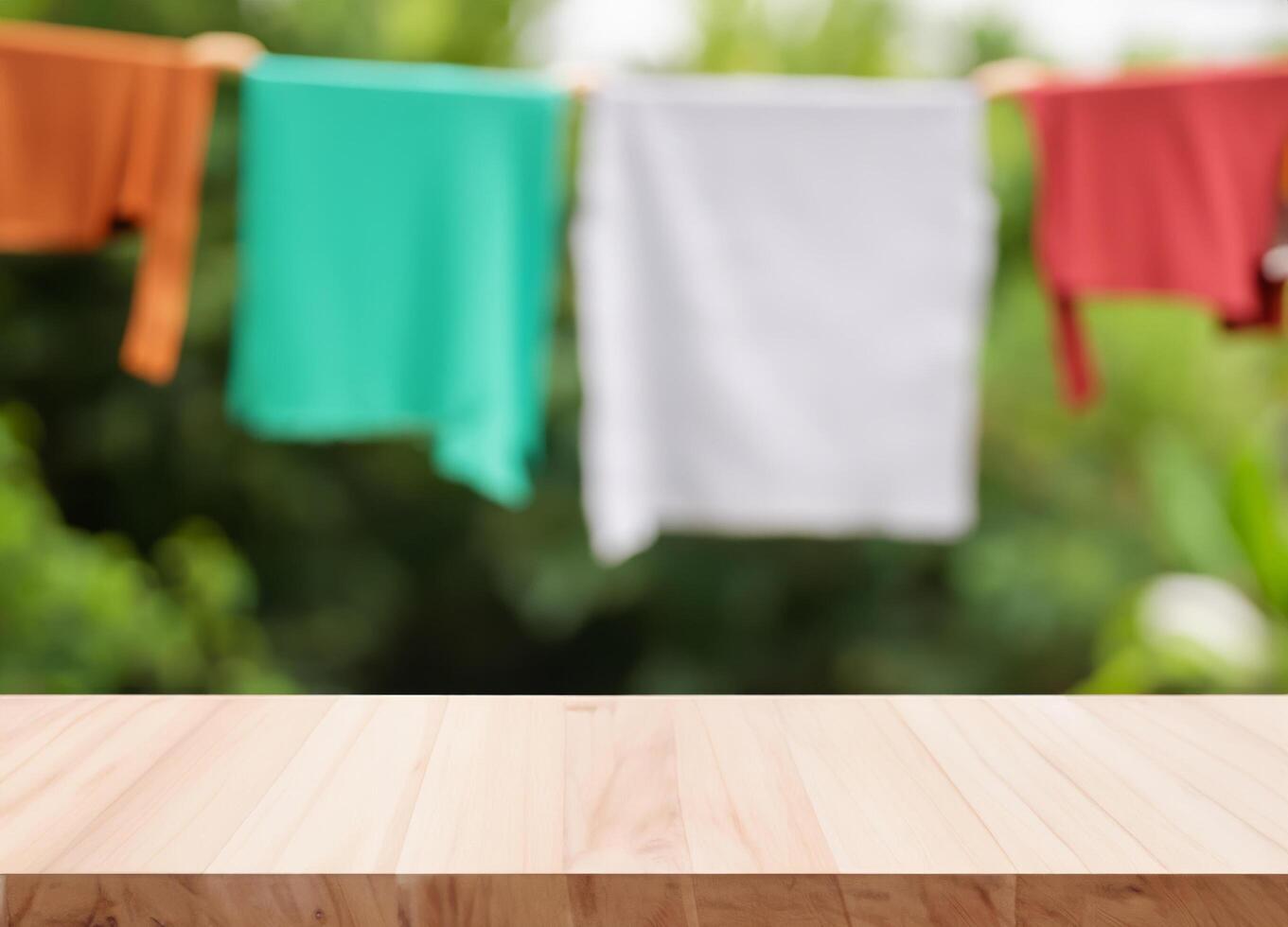 Wooden table with blurred cloth hanging in the garden photo