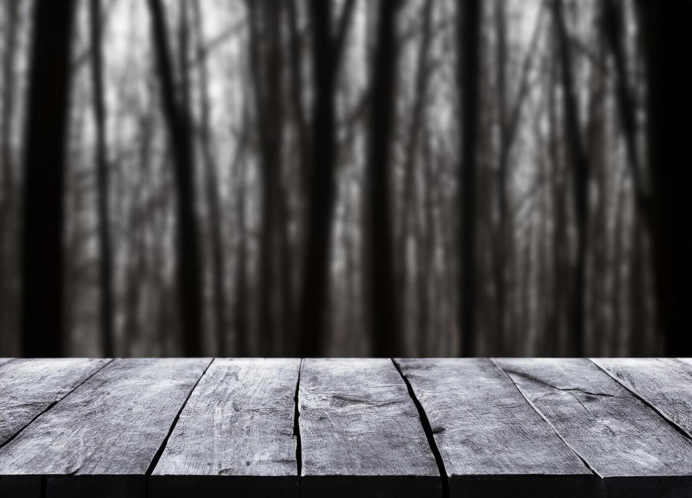 Black wood table with blurred horror forest photo