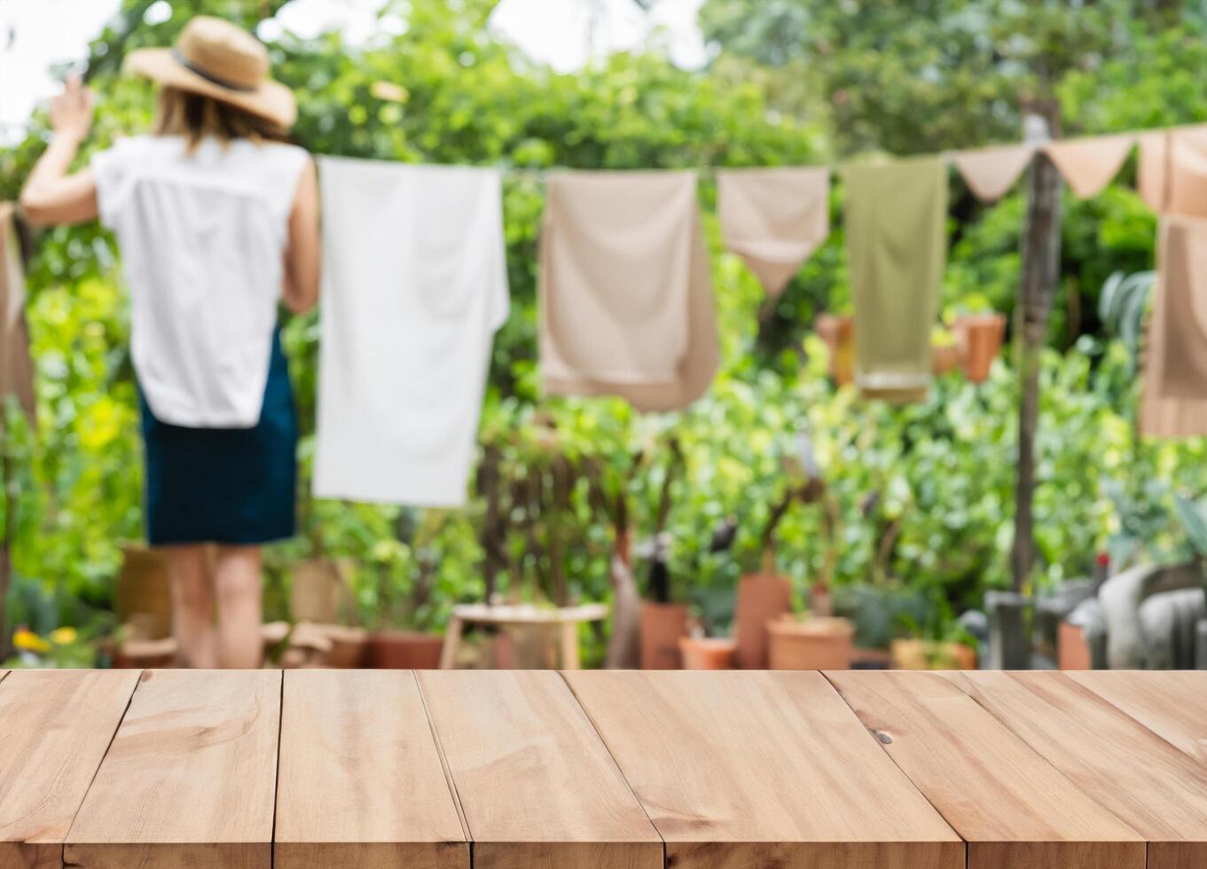 Wood table for display products on blurred woman hanging clothes in garden photo