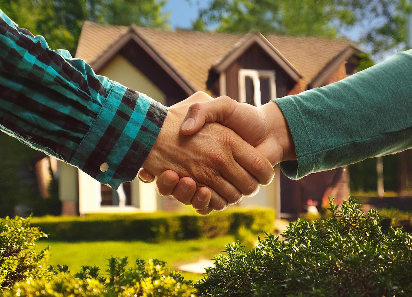 Close up of handshake with house for sale in background photo