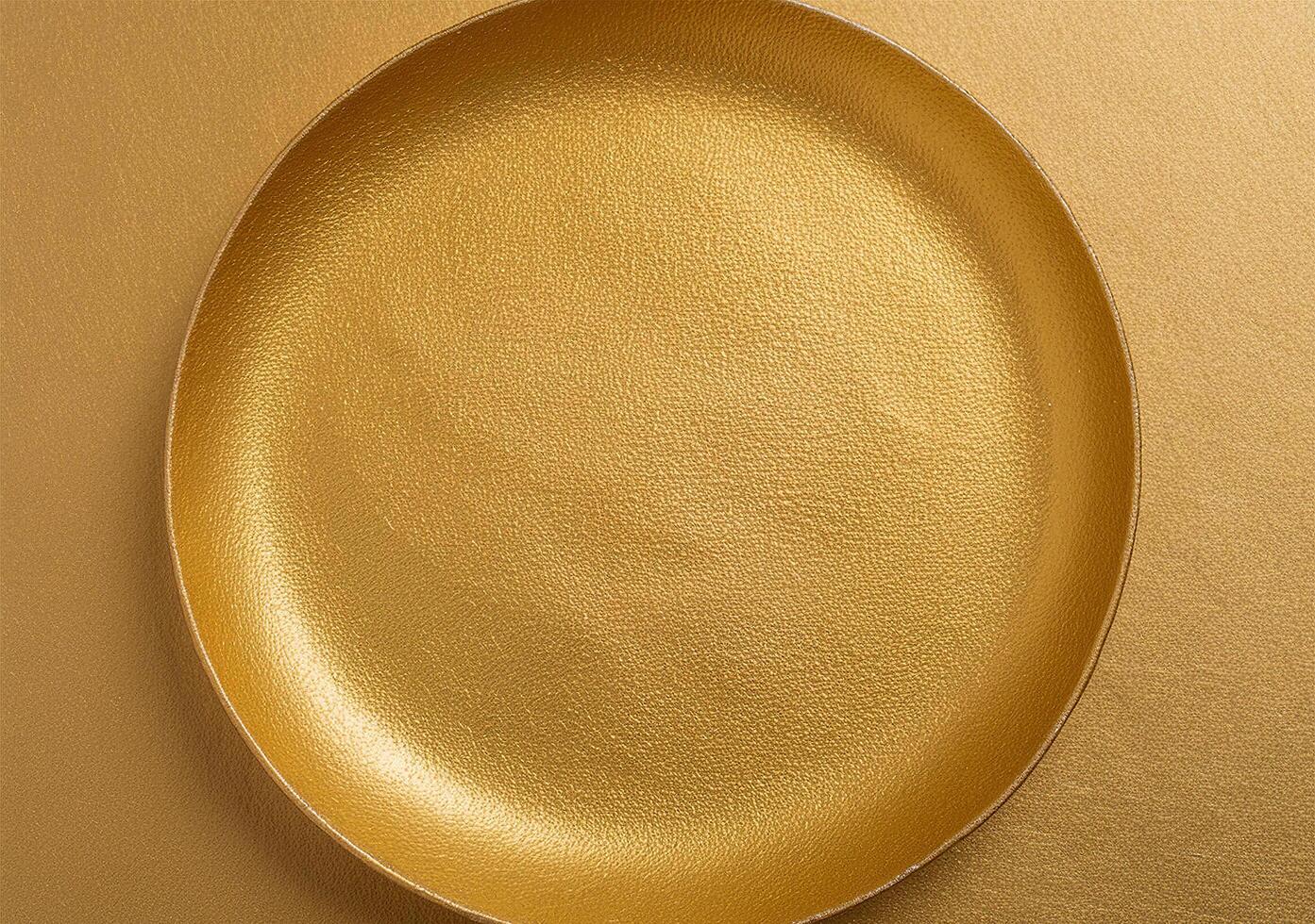 Top view of golden plate on gold background photo