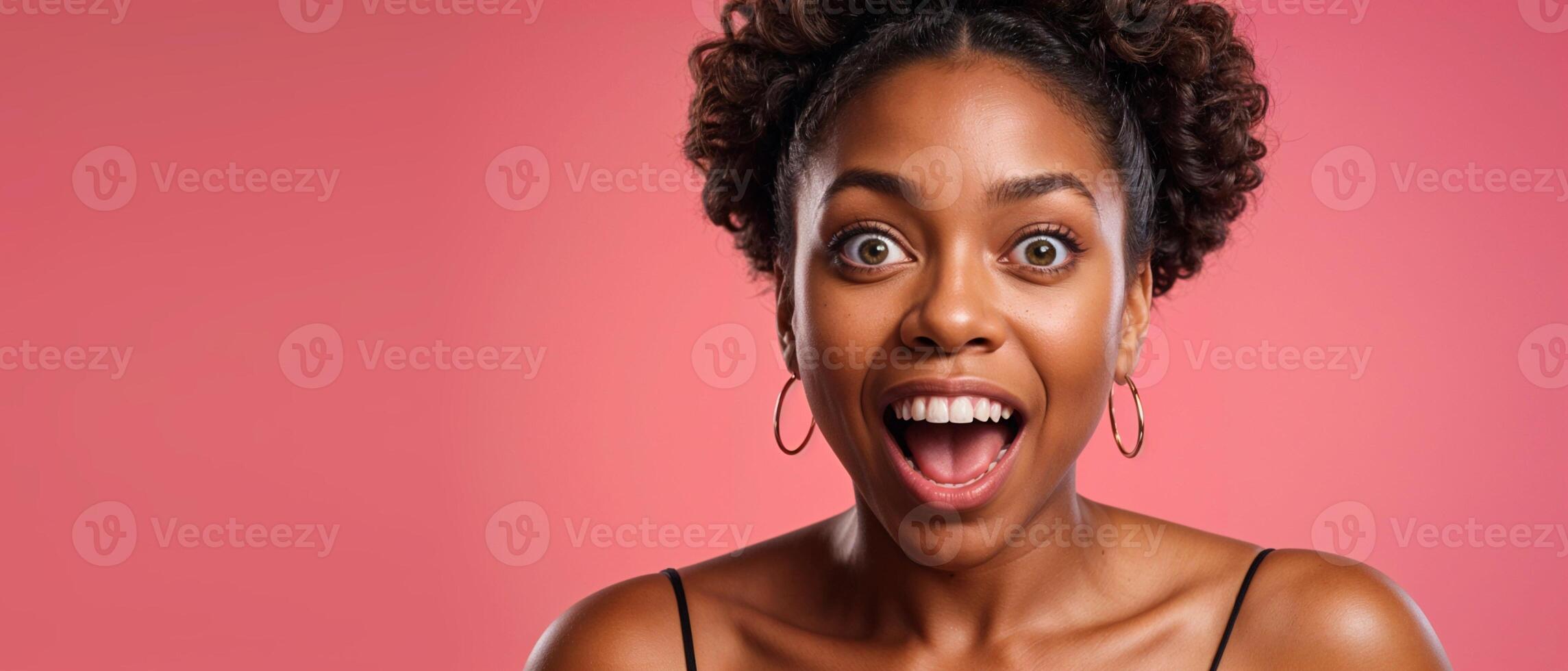 An isolated, studio portrait of a young, surprised African-American woman, with her mouth open, on a pink copy background. For banner design, website, promotional materials. High quality photo. photo