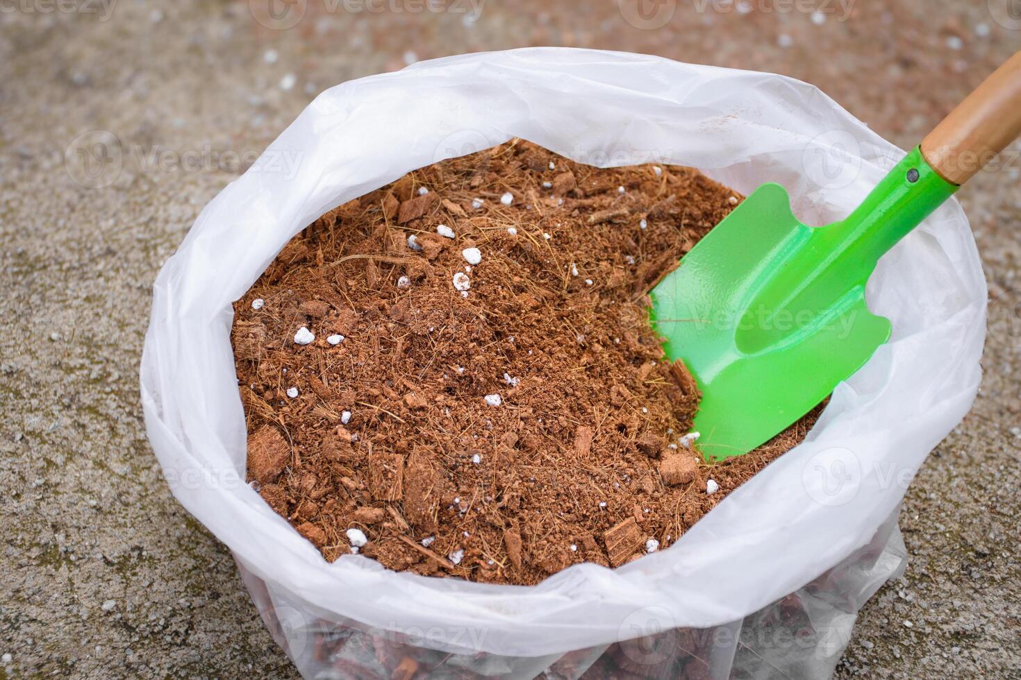 Soil fertilizer peat moss or cocopeat in bags and soil shovels are used for planting crops or preparing or mixing fertilizer. Top view of peat moss fertilizer bag selective focus on blurred background photo