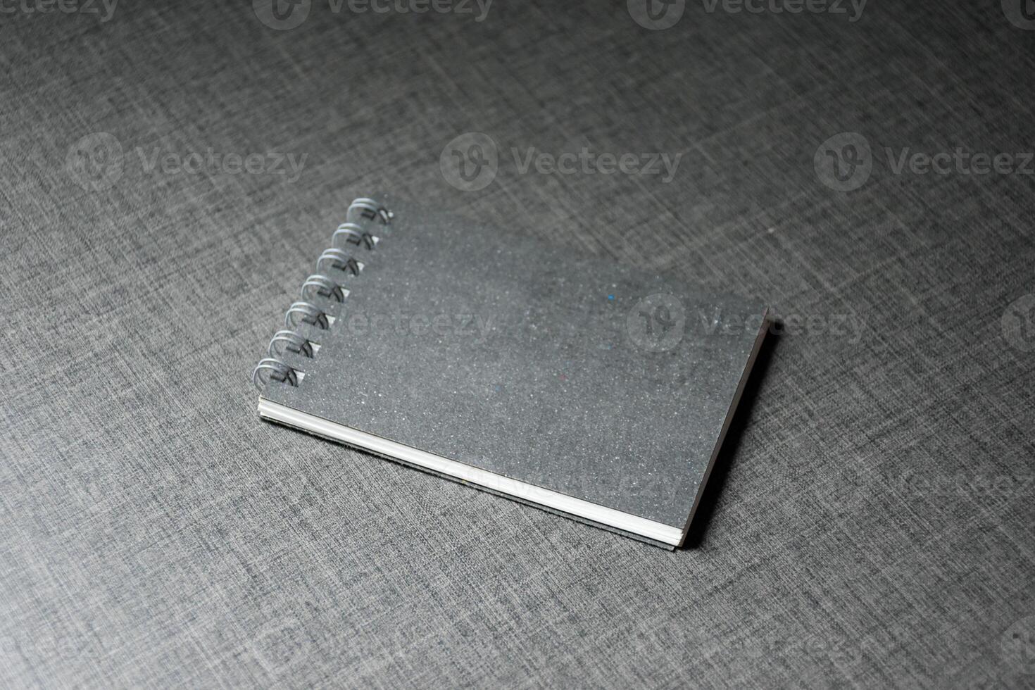 Black Blank Notebook on dark table wooden pattern background,mockup notebook,Blank black cover template with copy space for design,notebook isolated on dark background, concept of design and business. photo