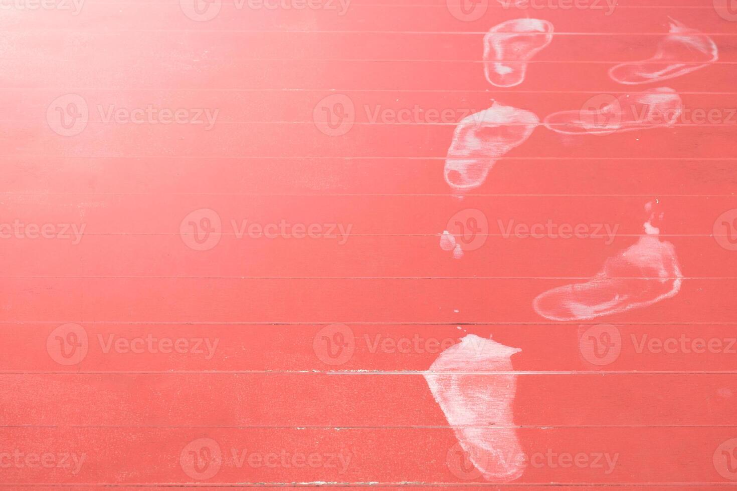 White footprints on red wood floor in soft sunlight blurred background for concept of mystery and theft. photo