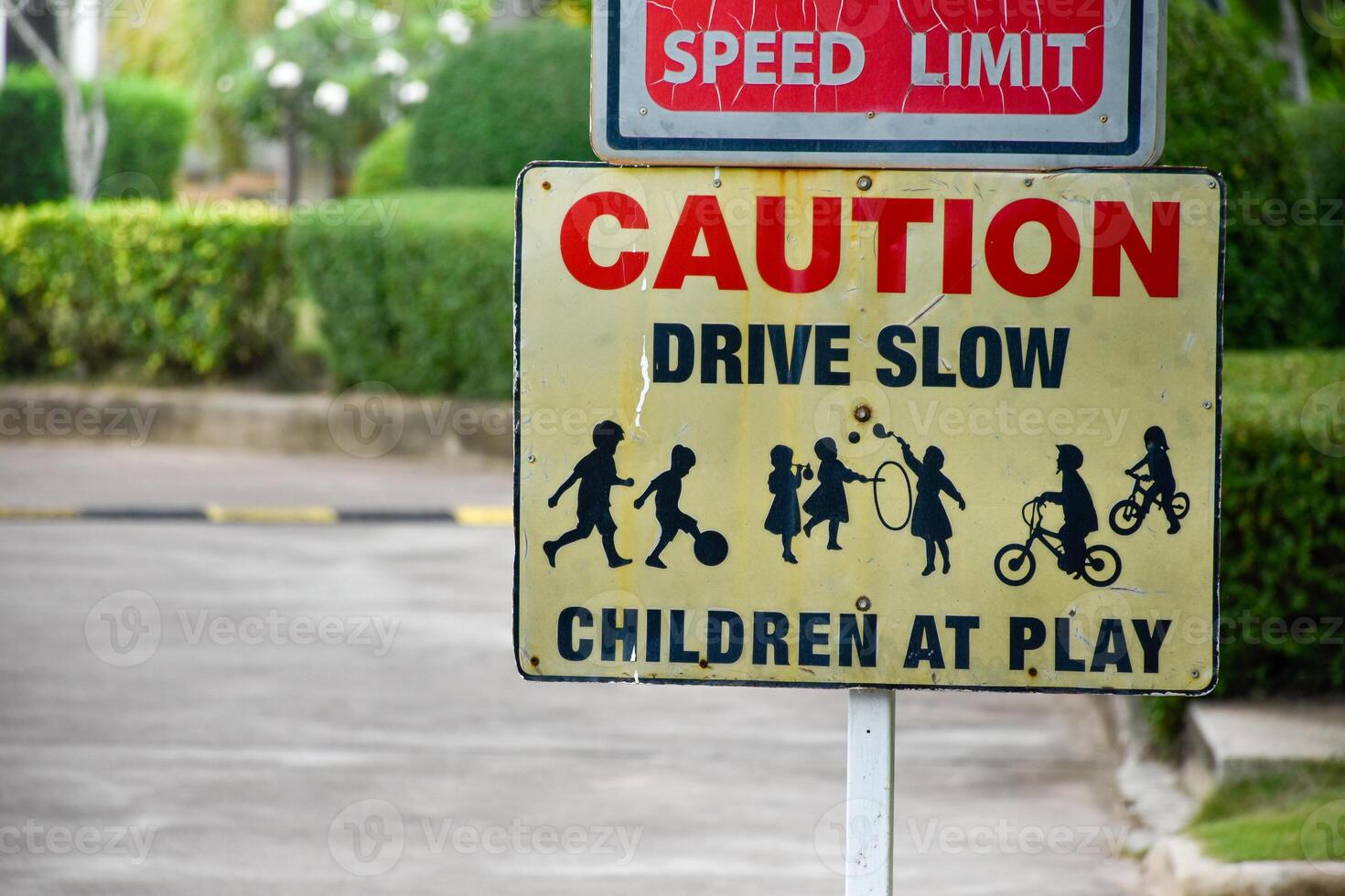 Sign caution speed limit drive slow children at play on yellow background at park in evening sunset, playground sign,landscape garden background. photo