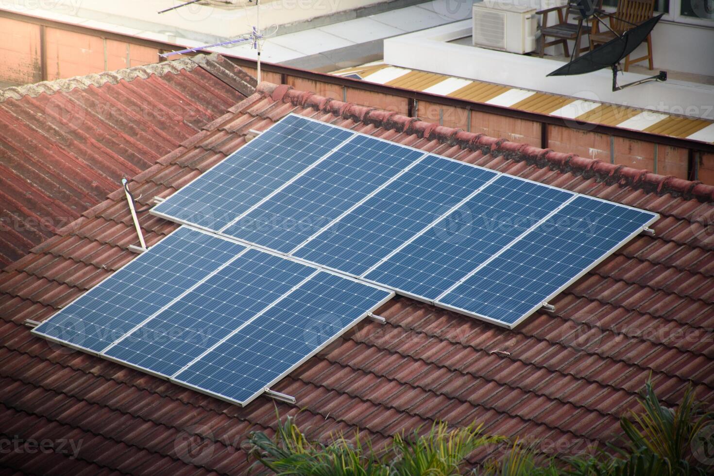 Solar panels on the roof of an orange house in the city for alternative energy and electricity saving concept. photo