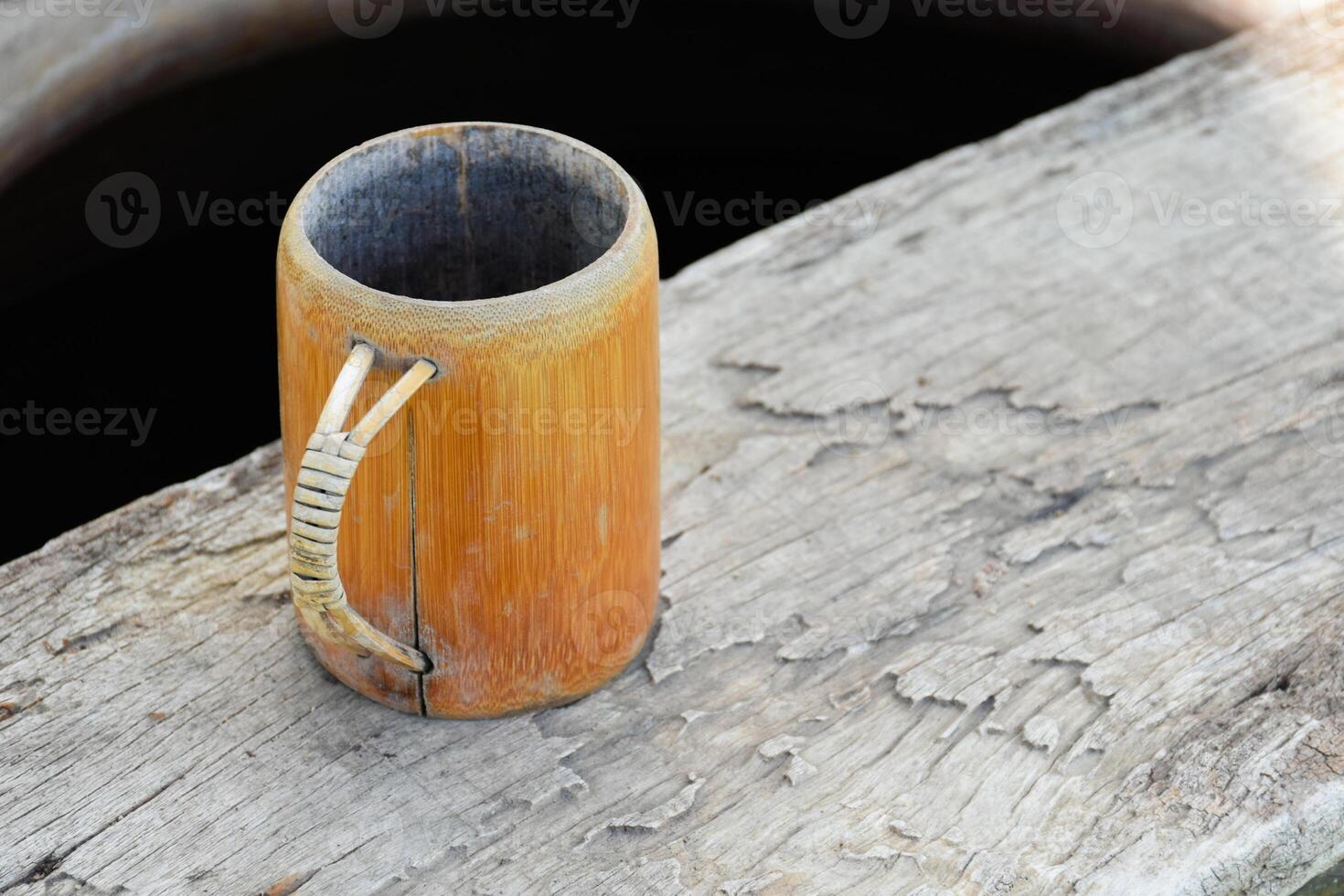Brown bamboo drinking glass on wooden background products made from natural used as a drinking container. photo