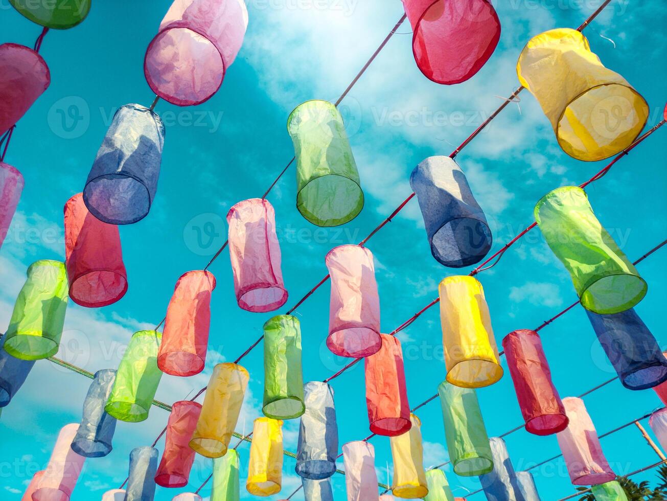 Colorful lanterns made from colored paper For decorating venues and decorating festivals on the sky neon tropical tones background. photo
