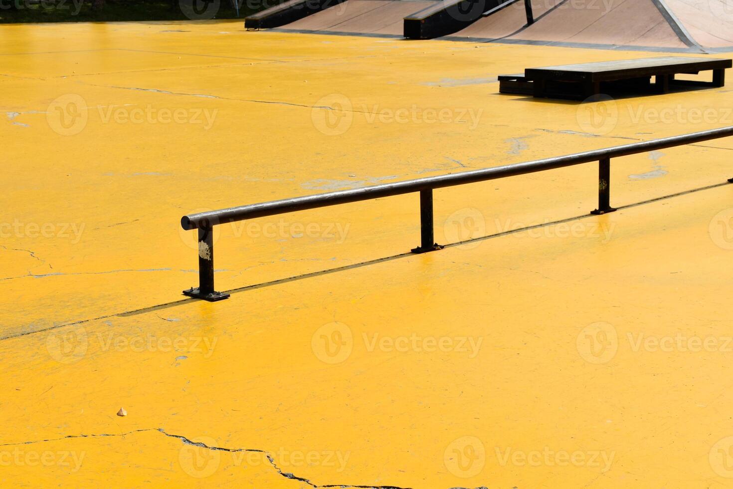 Black skateboard steel rail on a yellow concrete background is an area for skateboarding at an outdoor park. photo