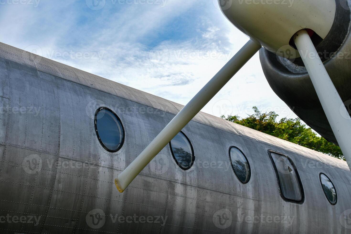 Front view of airplane body and propeller engine is an old commercial airplane that is no longer in use showing the surface of silver metal and parts. photo