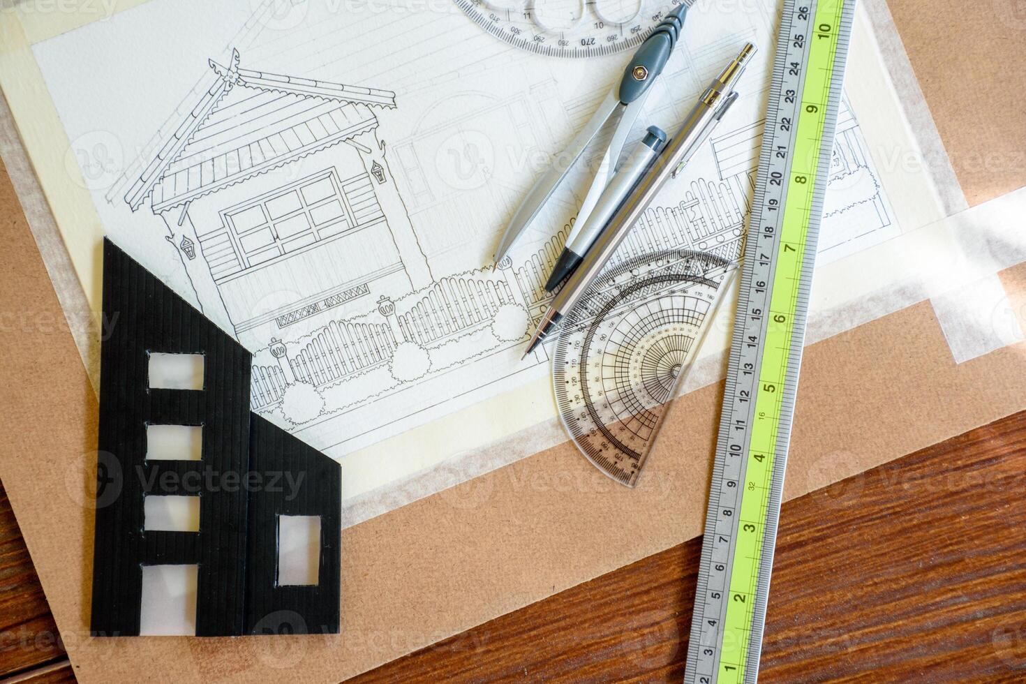 Top-view of architectural plans for building a house and miniature building models for engineering design or blueprints with tools like a pencil and ruler for sketching or drawing. photo