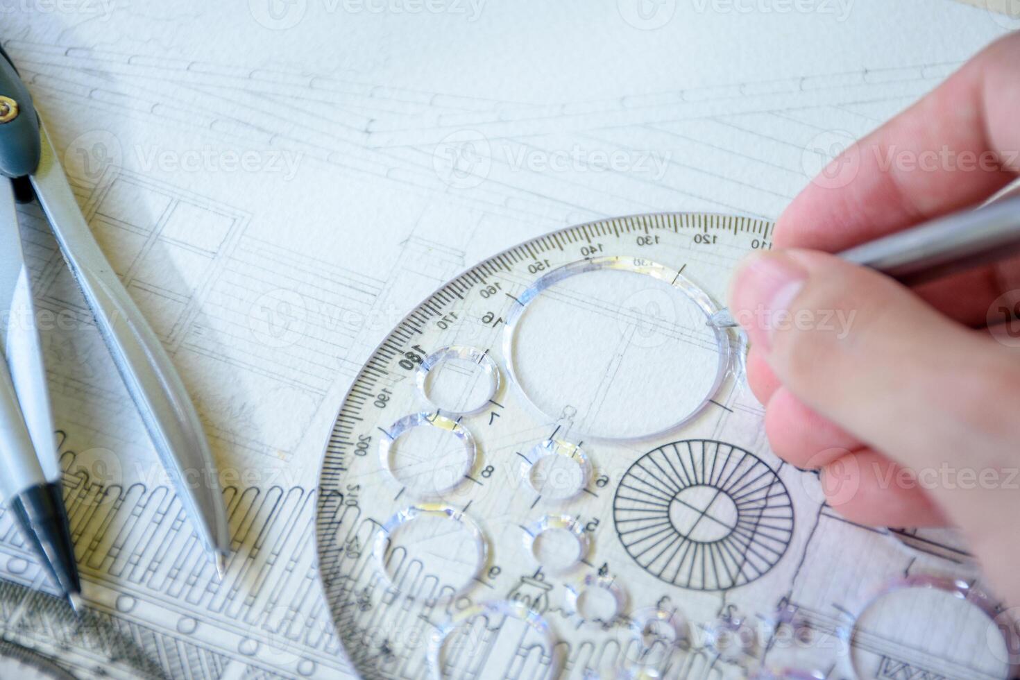 Selective focus of hand drawing line or sketching a house design or construction plan using a pencil and circle ruler on white paper with dividers for design and engineering concepts. photo