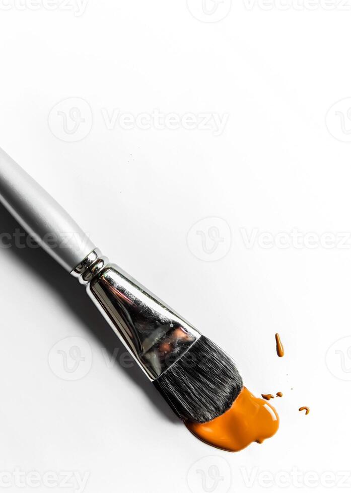 Brush and liquid foundation close-up isolated on white background photo