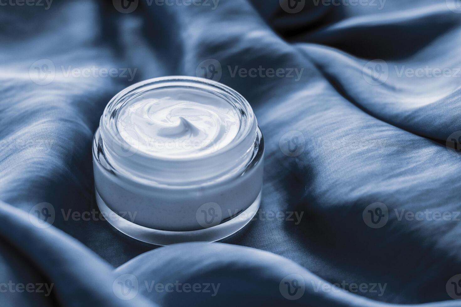 Beauty face cream jar on a soft blue silk photo