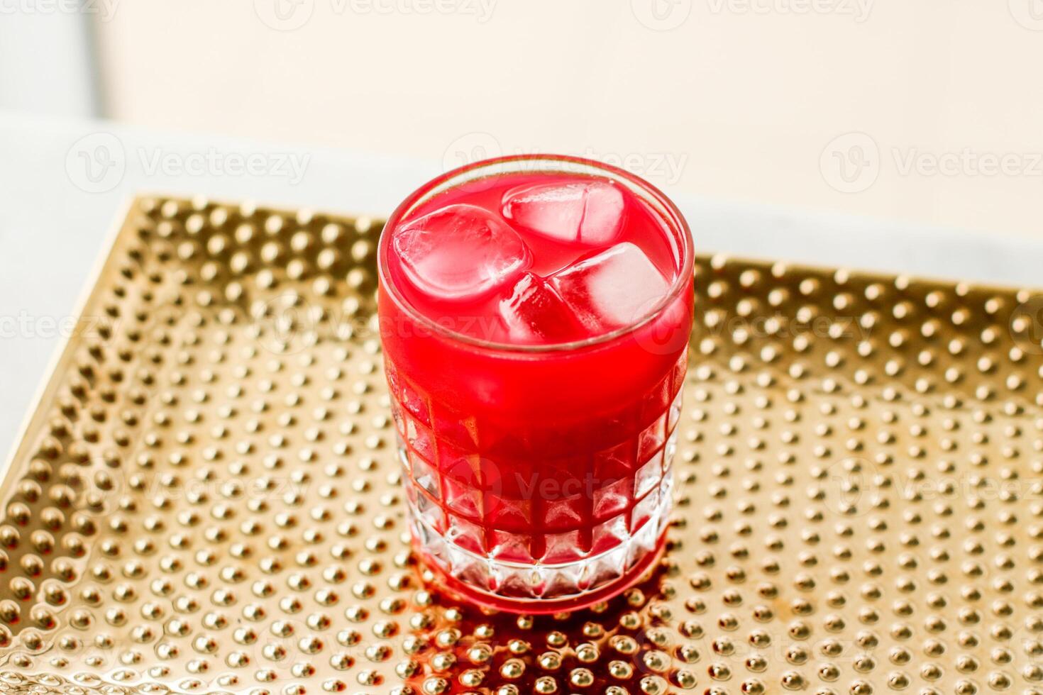 Glass of red cocktail with ice, luxury bar party photo