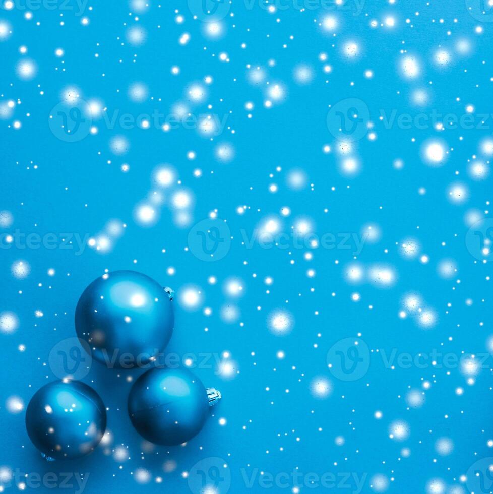 Christmas baubles on blue background with snow glitter, luxury winter holiday card photo