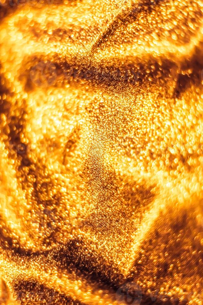 Golden holiday sparkling glitter abstract background, luxury shiny fabric material for glamour design and festive invitation photo