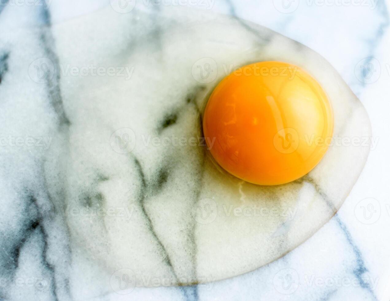 egg yolk on marble - recipe ingredients and homemade cooking concept photo