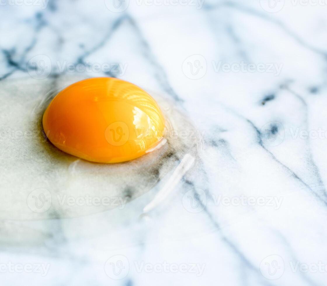 egg yolk on marble - recipe ingredients and homemade cooking concept photo