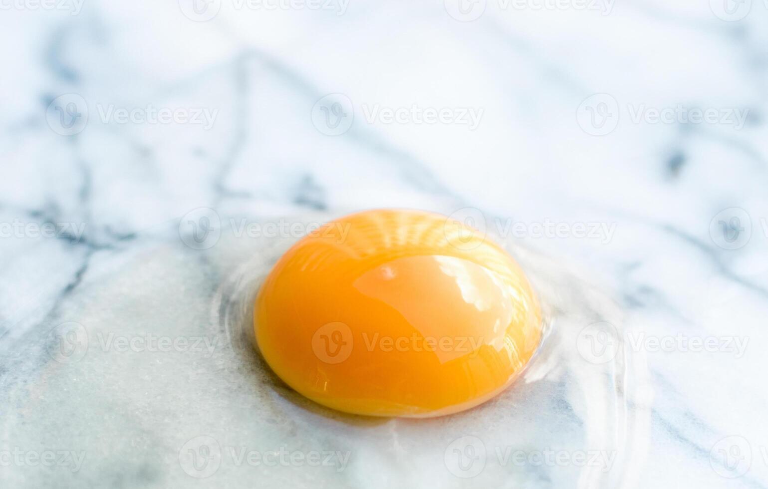 egg yolk on marble - recipe ingredients and homemade cooking concept photo