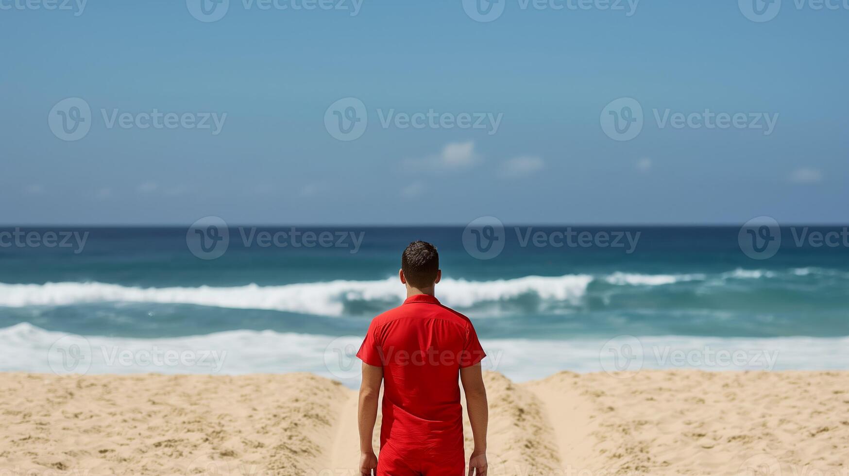 Lifeguard in a stylish red jacket patrolling the golden sands with azure waves in the background photo
