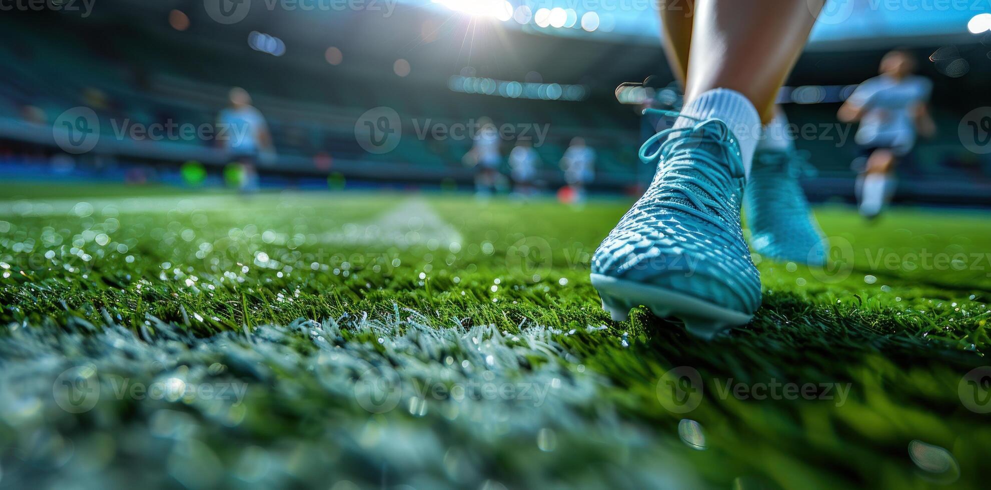 Close up of a soccer player's foot in a blue shoe on a football stadium field background with copy space. photo