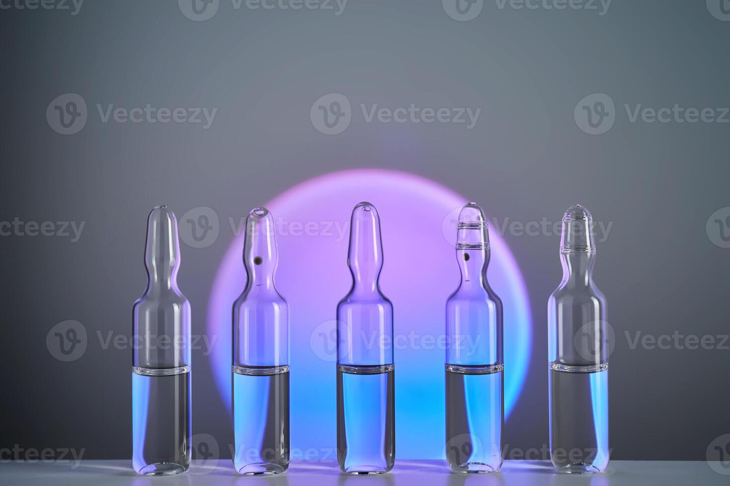 Several ampoules for injection with medicines on a purple background. photo