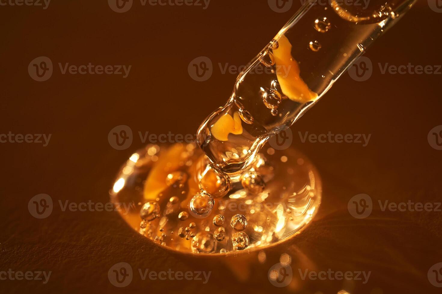 Pipette with serum shimmering in the sun on a beige background. photo