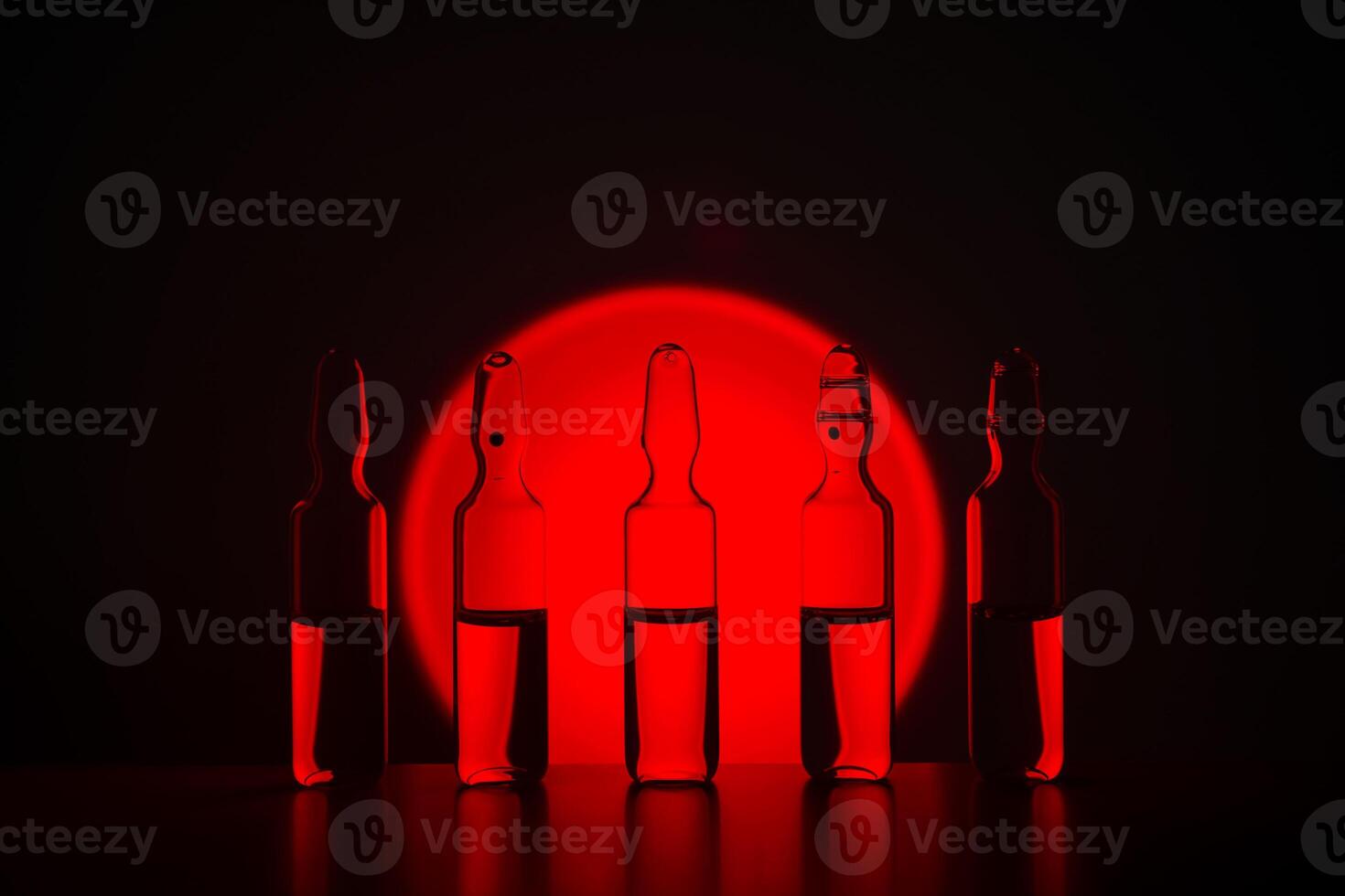 Several ampoules for injection with medicines on a blue background. photo