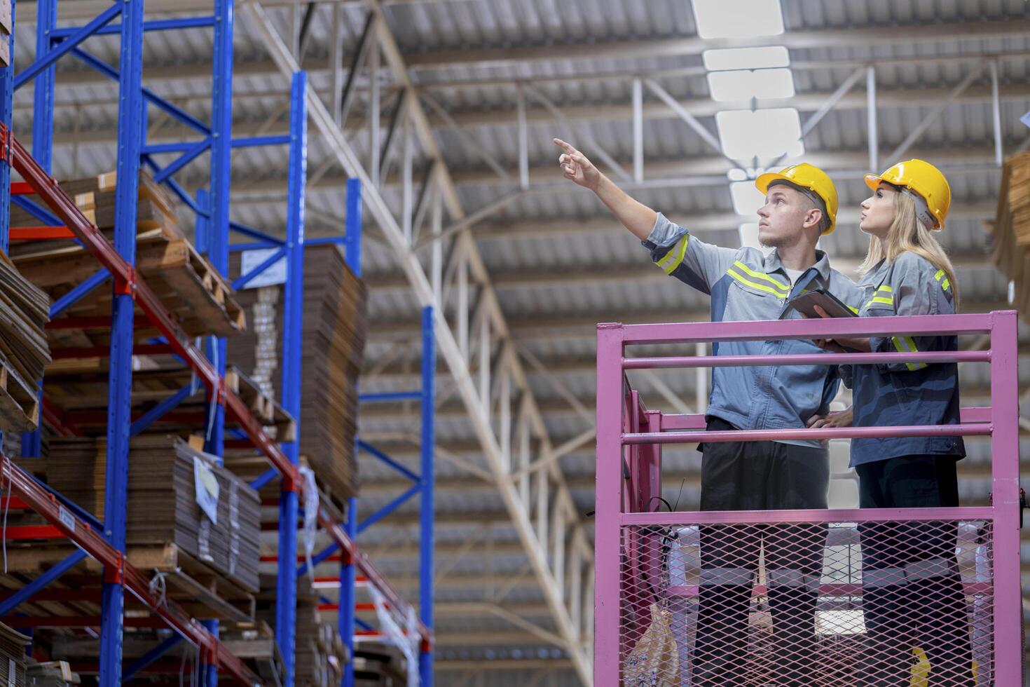 workers man and woman using a hydraulic scissor lift to check stock near the shelves warehouse. industry factory warehouse. Worker Screening Package In Warehouse. photo