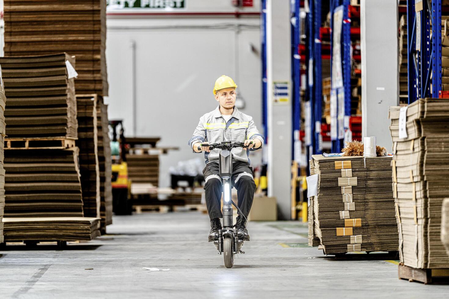 man riding electric bicycle and checking stock items for shipping. male inspecting the store factory. Logistics employees holding folders at on site warehouse area for shipping transportation. photo