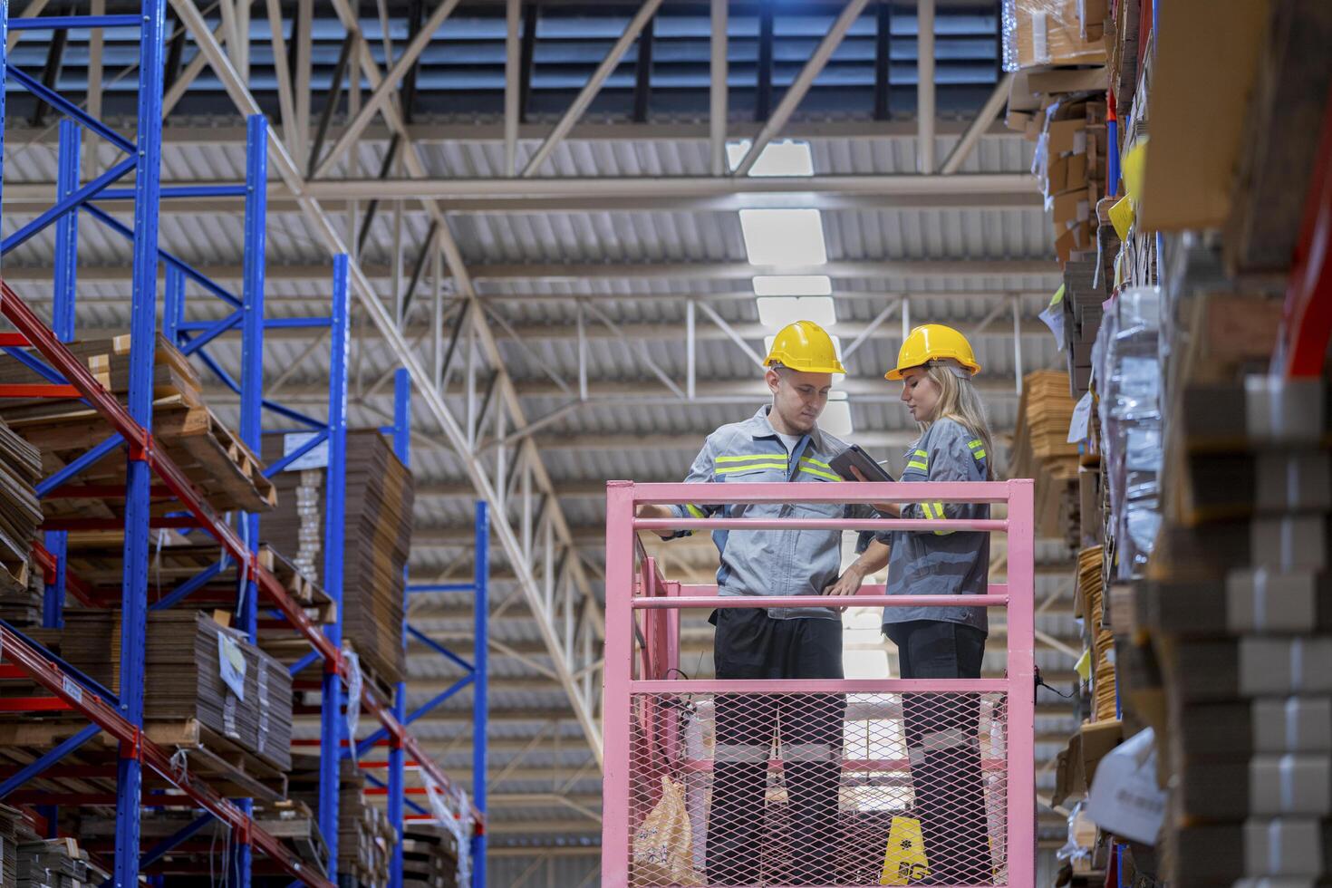workers man and woman using a hydraulic scissor lift to check stock near the shelves warehouse. industry factory warehouse. Worker Screening Package In Warehouse. photo