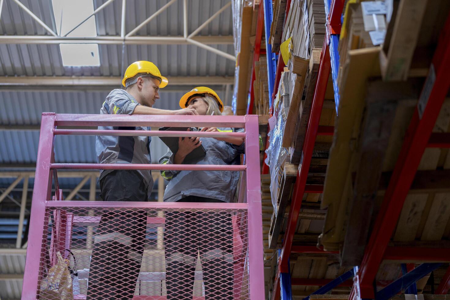 workers man and woman using a hydraulic scissor lift to check stock near the shelves warehouse. industry factory warehouse. Worker Screening Package In Warehouse. photo