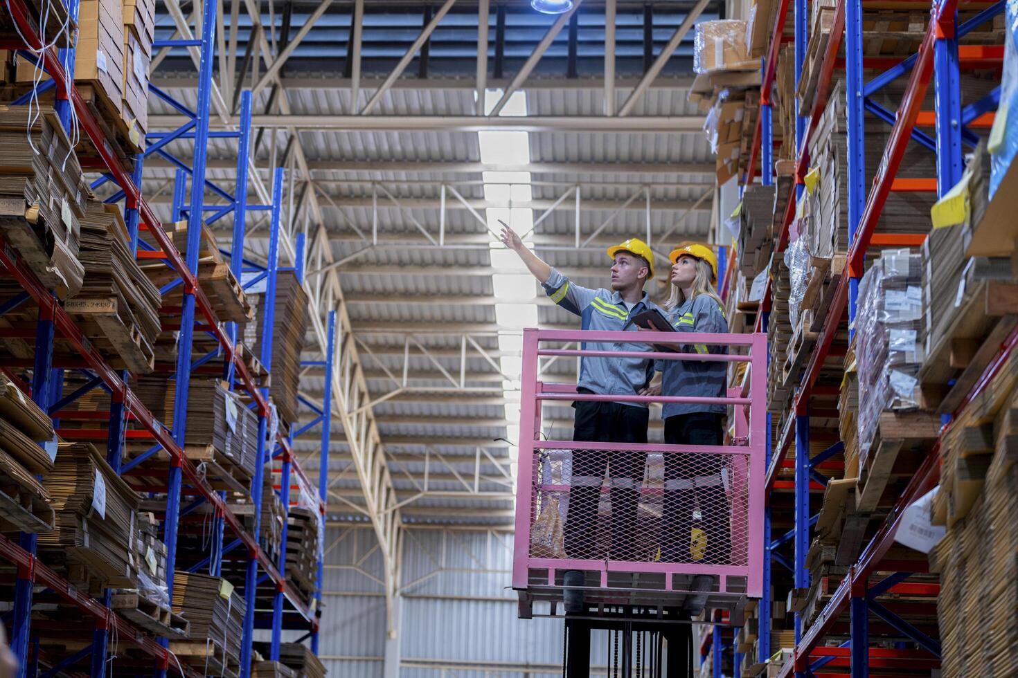 workers man and woman using a hydraulic scissor lift to check stock near the shelves warehouse. industry factory warehouse. Worker Screening Package In Warehouse. photo