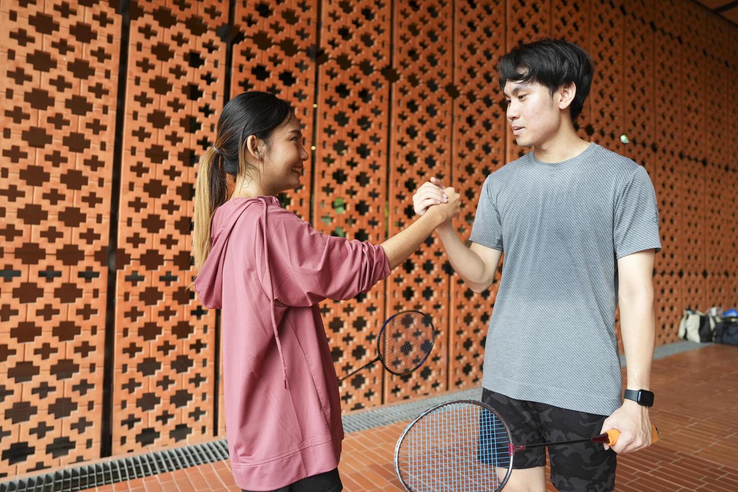 Young people play badminton and repair diligently in the park area. photo