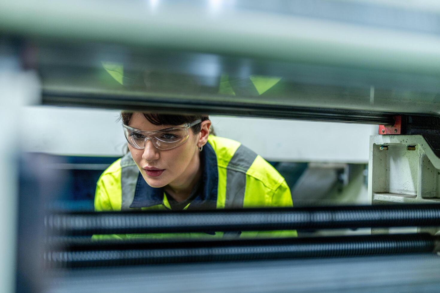 Male and female engineers in neat work clothes prepare and control the production system of large modern machines in a factory producing industrial technology products. photo