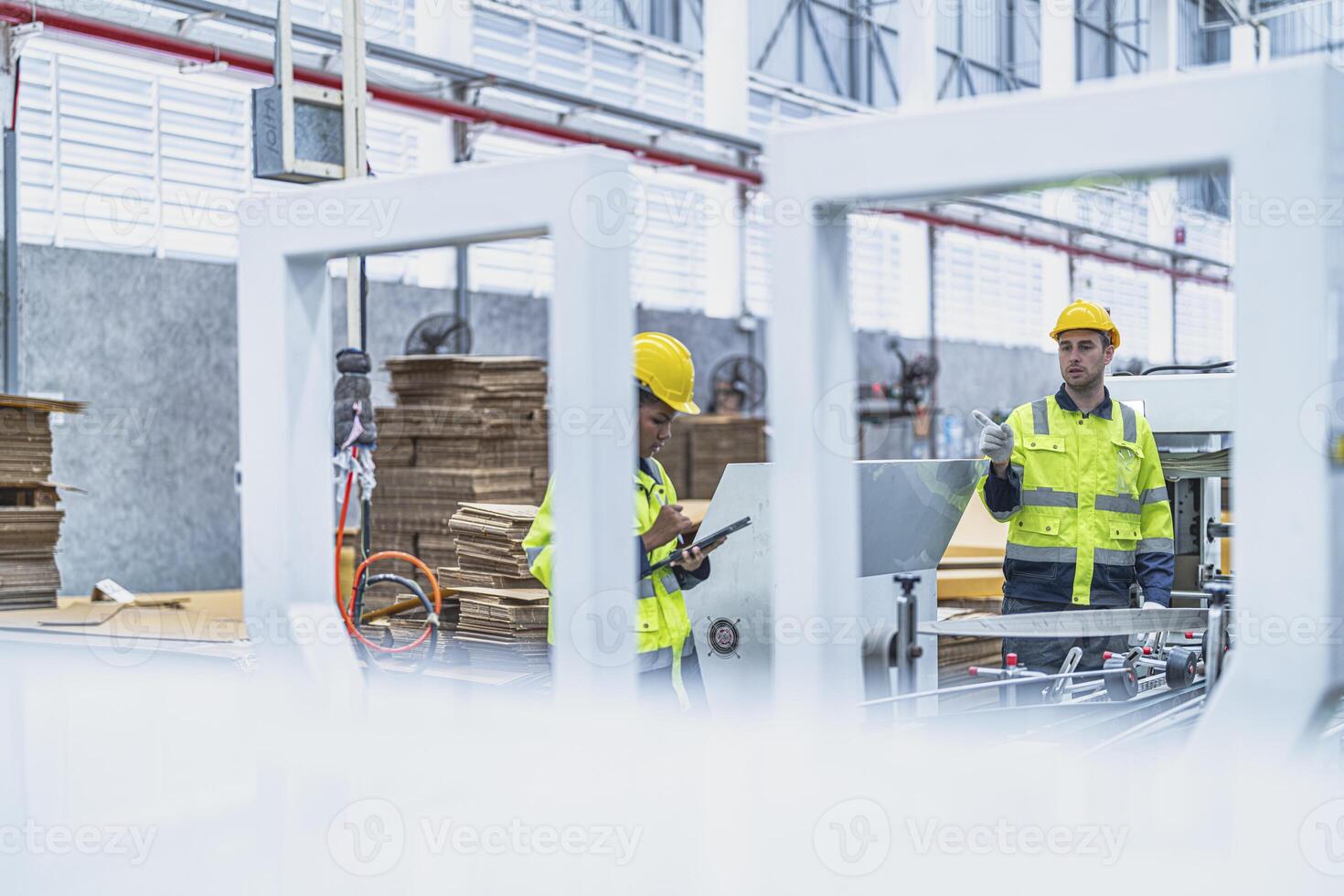 male and female technician engineers checking the process on Heavy machine. mechanical engineering team production. Industry manufacturing. Worker holding tablet and folde. High technology production. photo