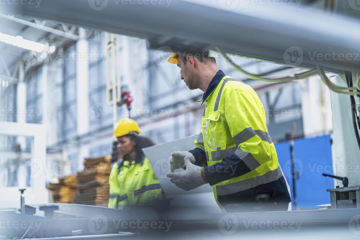male and female technician engineers checking the process on Heavy machine. mechanical engineering team production. Industry manufacturing. Worker holding tablet and folde. High technology production. photo