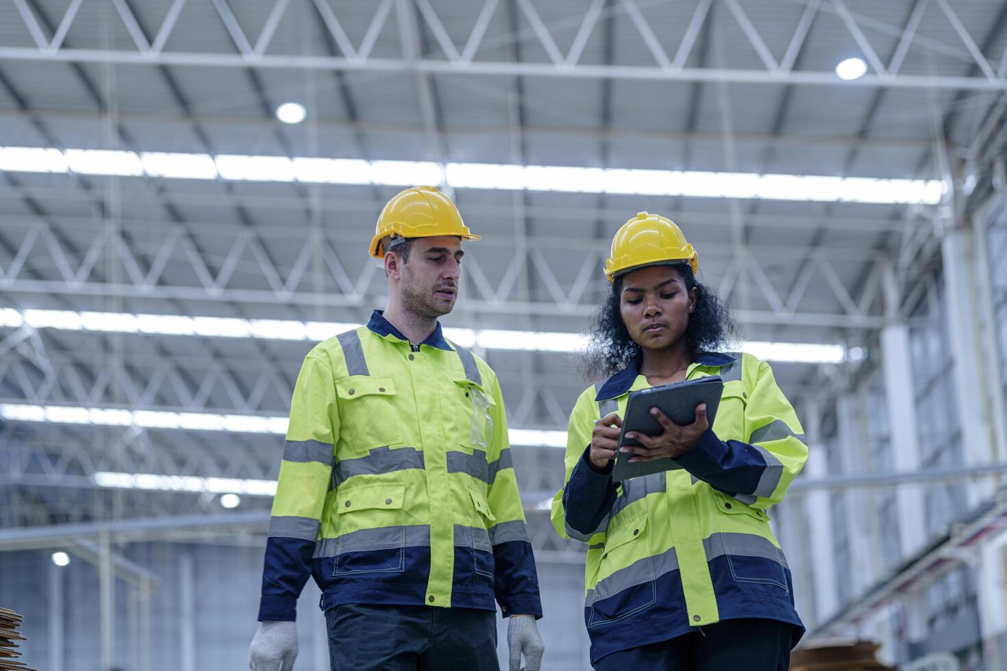 Male and female engineers in neat work clothes prepare and control the production system of large modern machines in a factory producing industrial technology products. photo