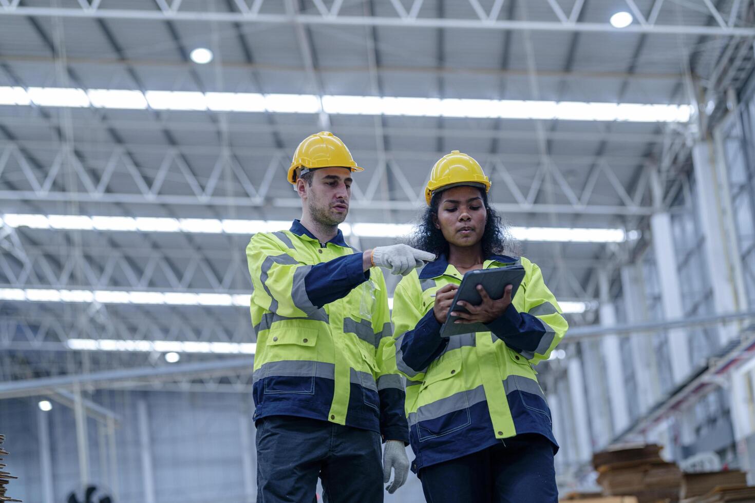 Male and female engineers in neat work clothes prepare and control the production system of large modern machines in a factory producing industrial technology products. photo