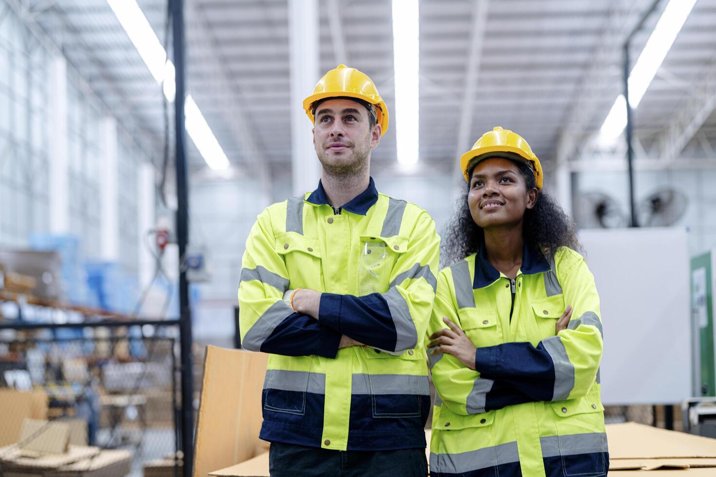 Male and female engineers in neat work clothes prepare and control the production system of large modern machines in a factory producing industrial technology products. photo