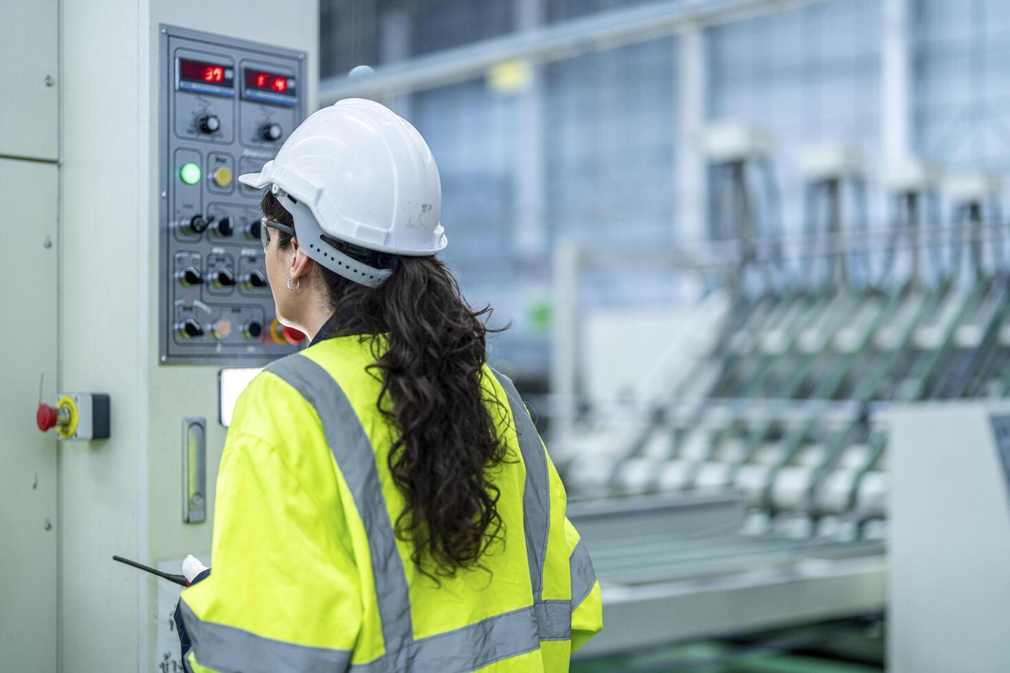 Male and female engineers in neat work clothes prepare and control the production system of large modern machines in a factory producing industrial technology products. photo