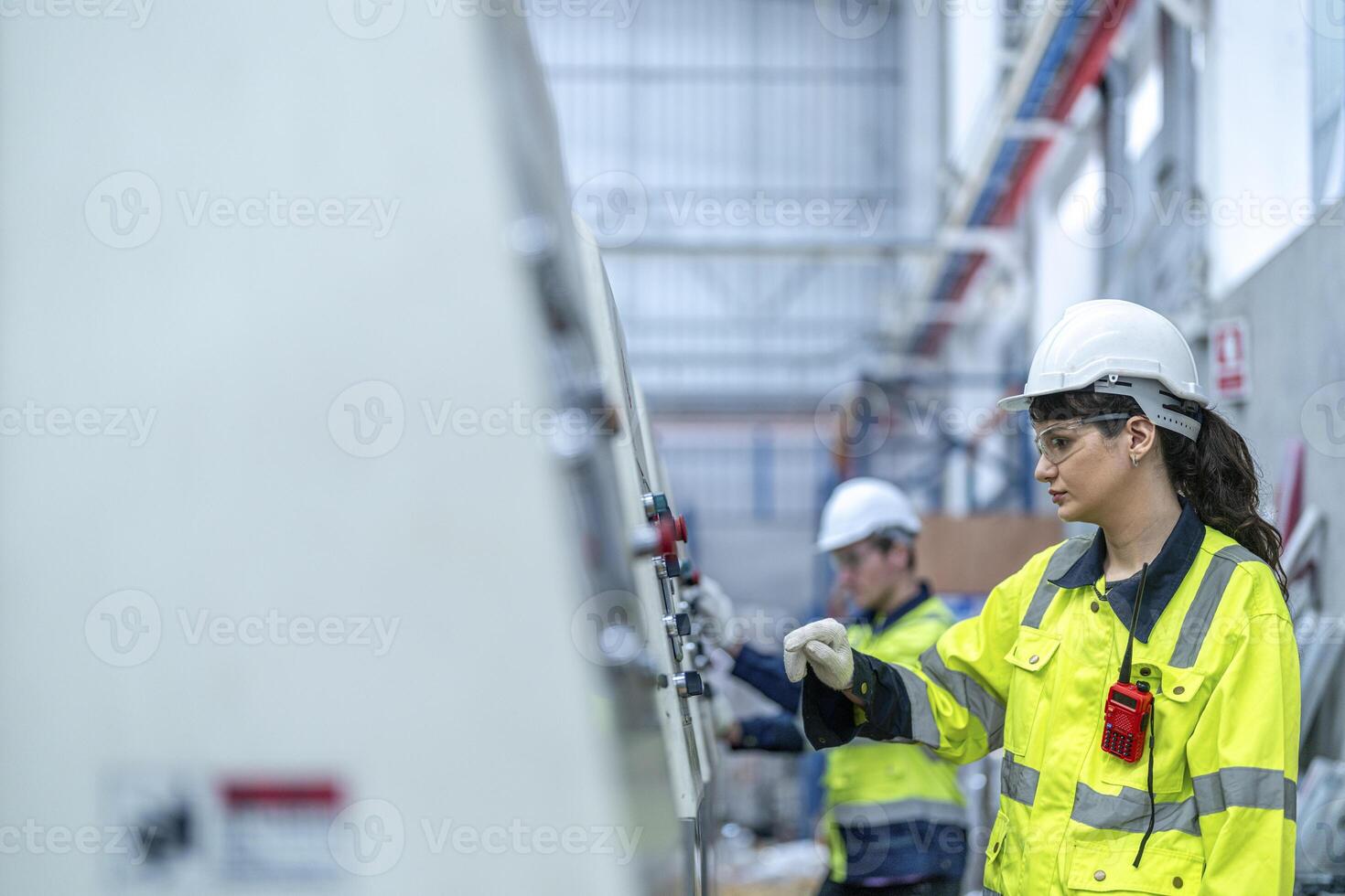 Male and female engineers in neat work clothes prepare and control the production system of large modern machines in a factory producing industrial technology products. photo