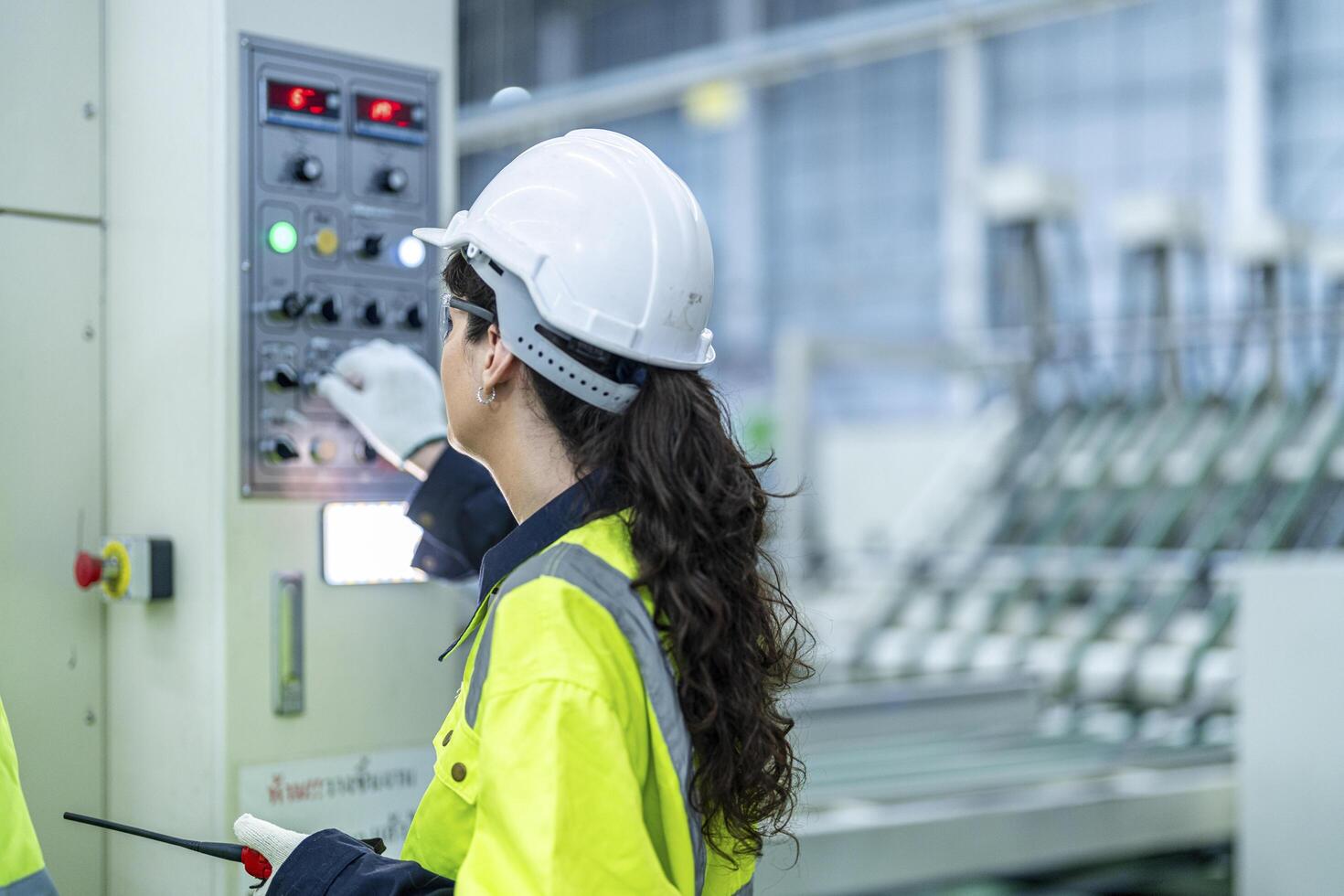 Male and female engineers in neat work clothes prepare and control the production system of large modern machines in a factory producing industrial technology products. photo
